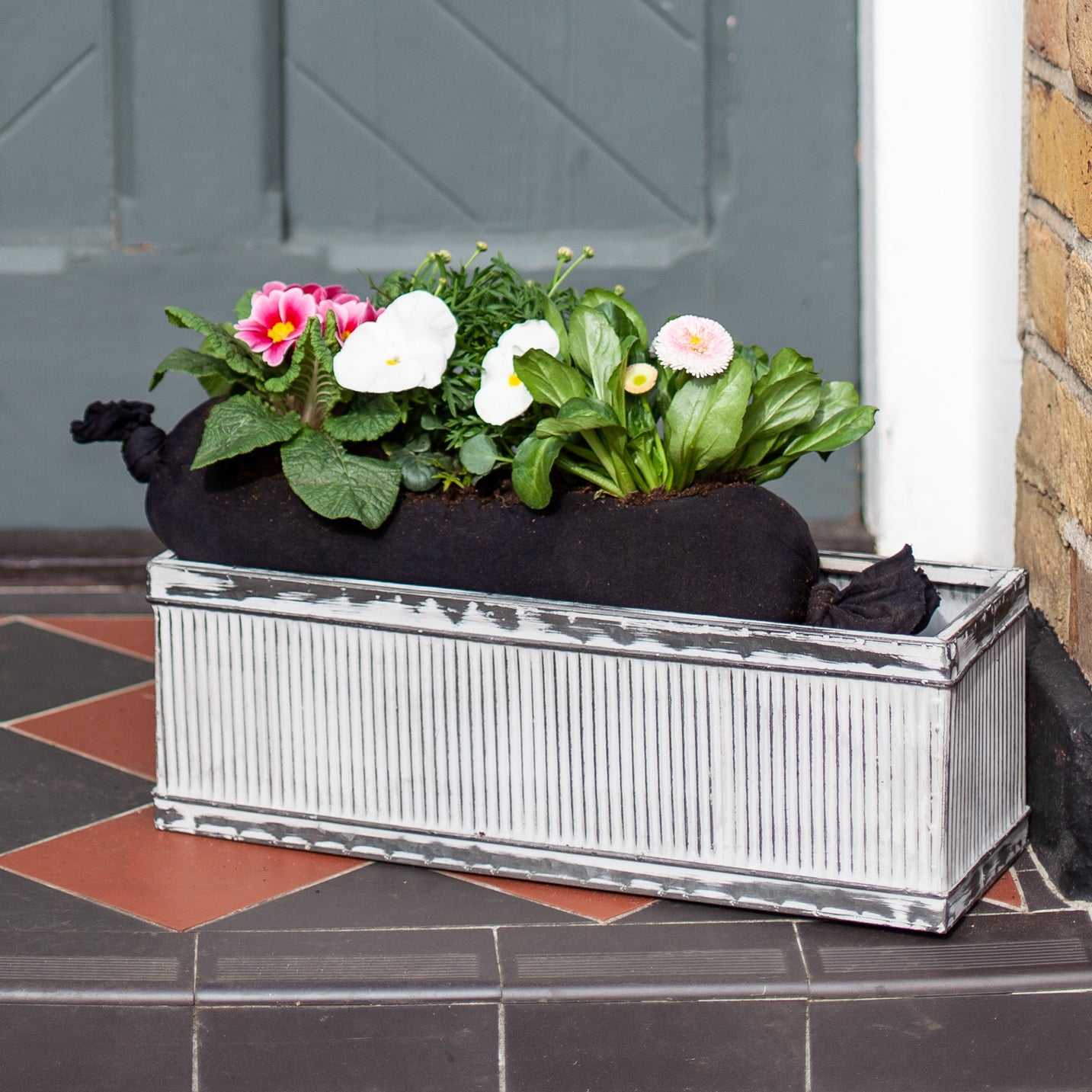 Pink and white planted flowers on a door step