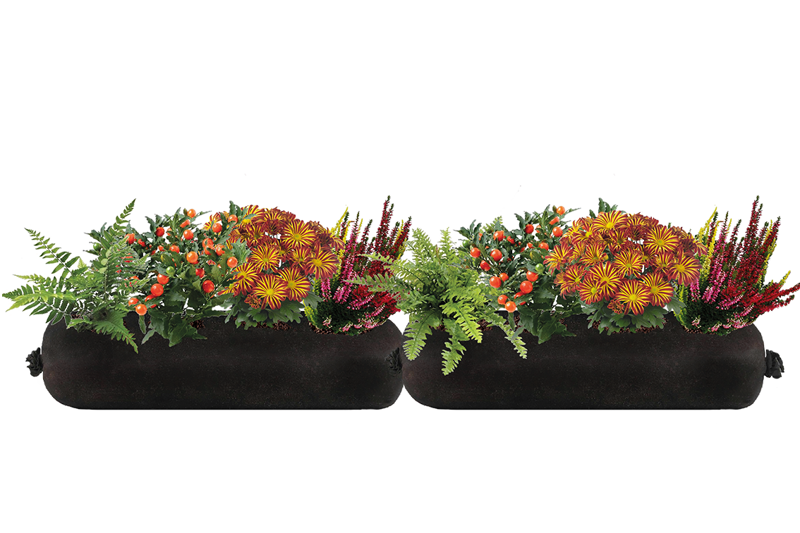 Two black fabric planters filled with flowers and greenery on a white background