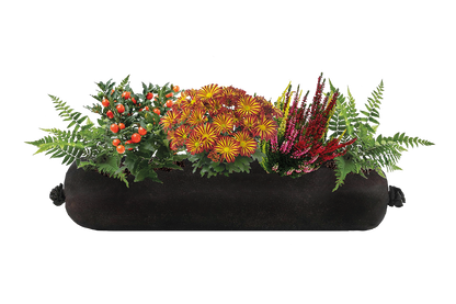 Black fabric planter with a variety of colorful flowers and plants on a white background