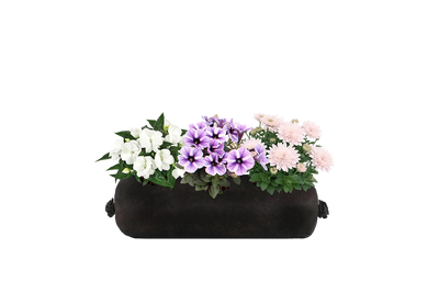 Black fabric planter with colorful flowers on a white background